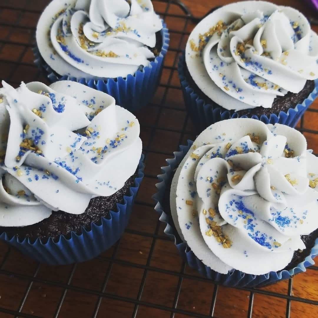 Blue and white celebration cupcakes with gold sprinkles by Jamie Cakes.