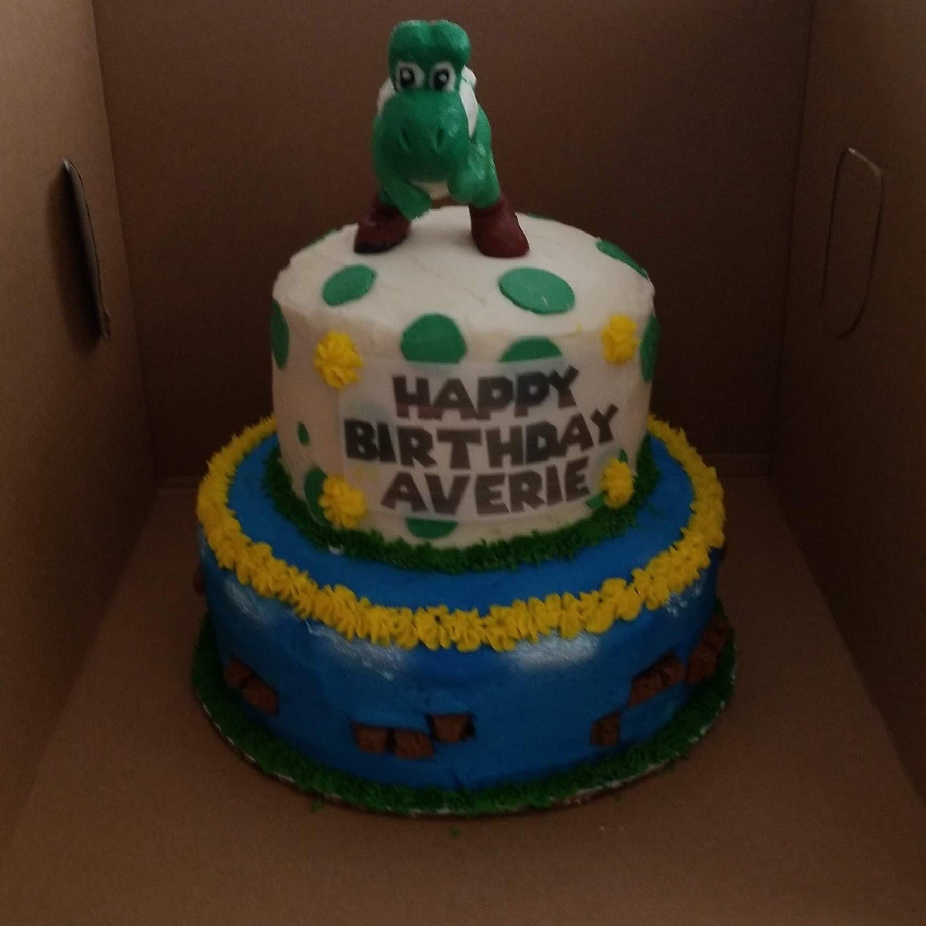 Two-tier crocodile birthday cake with blue and yellow accents by Jamie Cakes.