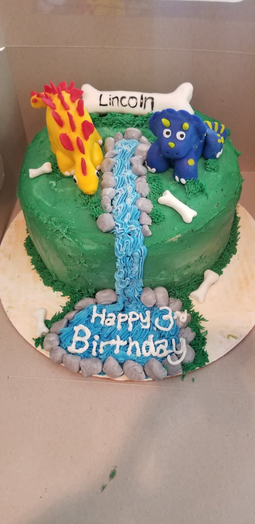 Dinosaur birthday cake with waterfall detail and bright jungle colors by Jamie Cakes.