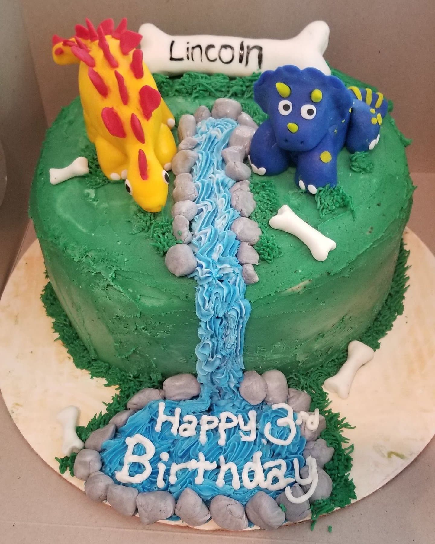 Close-up of a dinosaur waterfall birthday cake by Jamie Cakes.