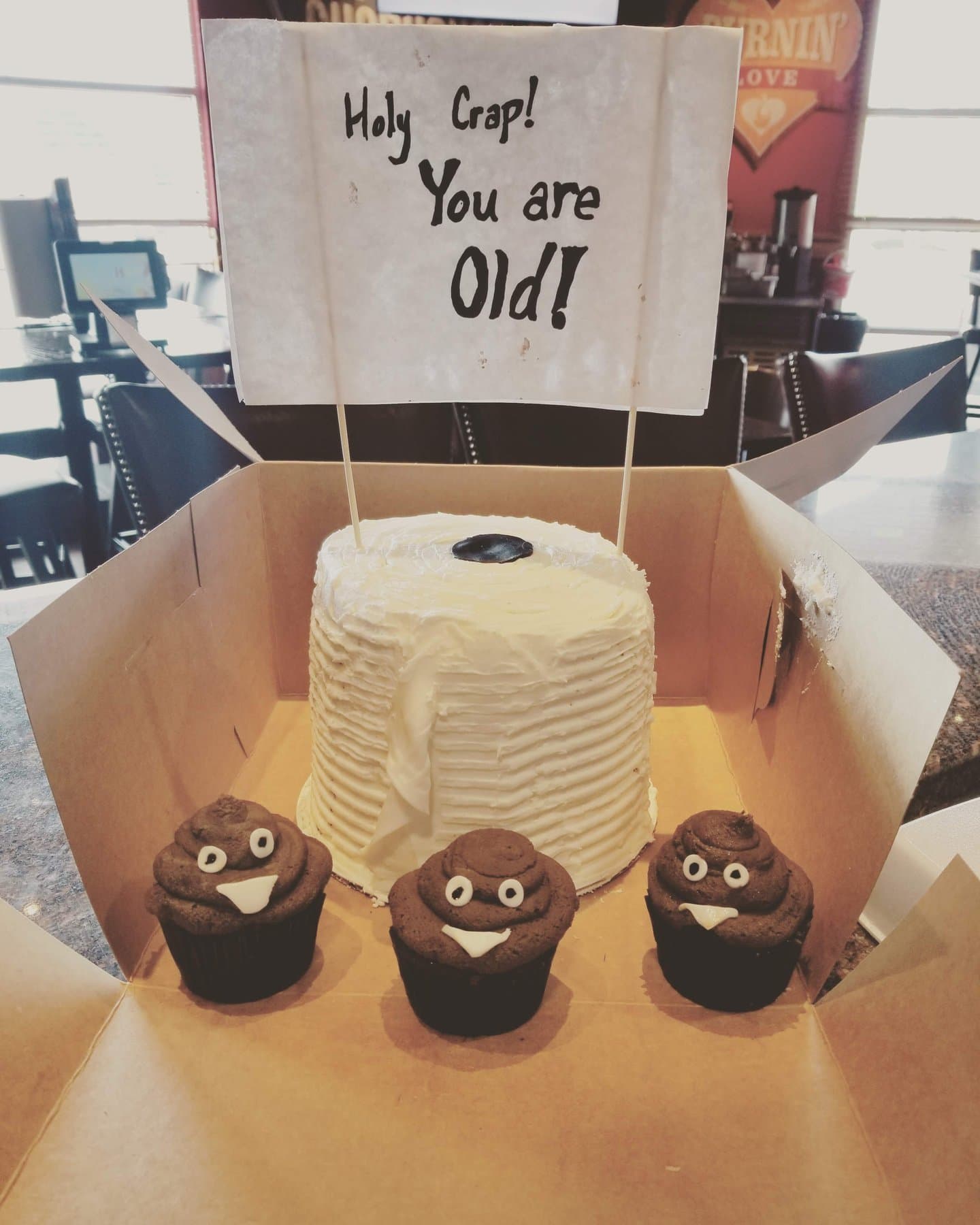 Over the hill novelty cake with matching poop emoji cupcakes by Jamie Cakes.