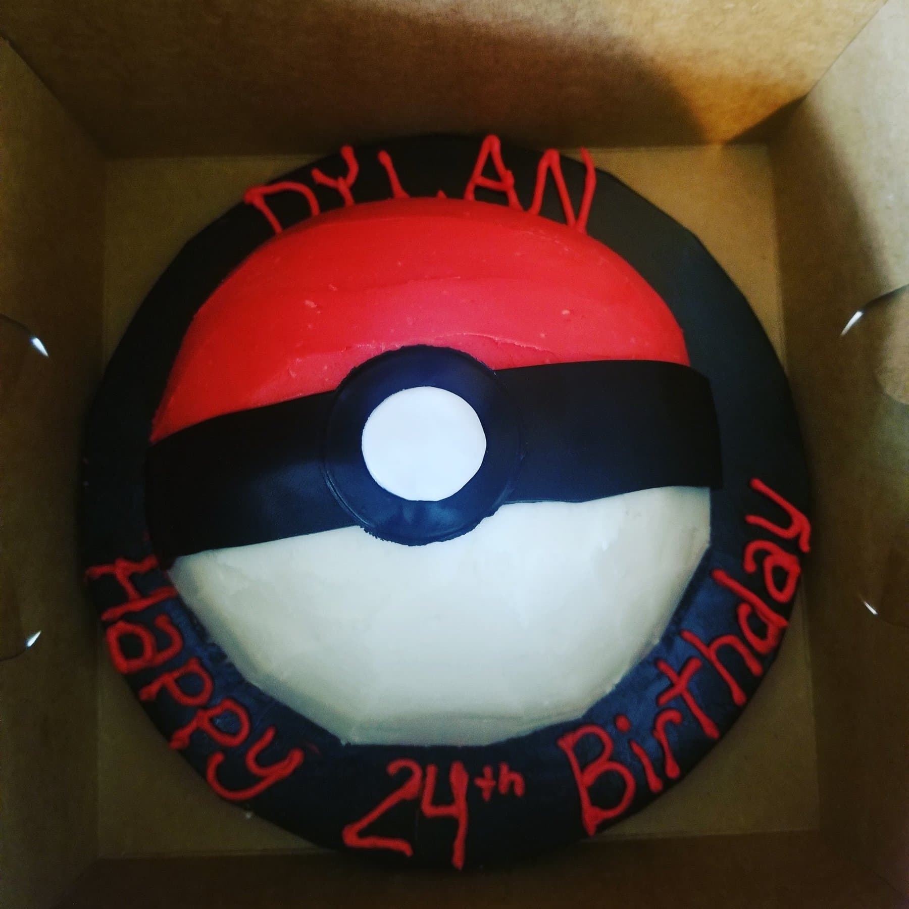 Pokeball birthday cake with bold red and black frosting by Jamie Cakes.