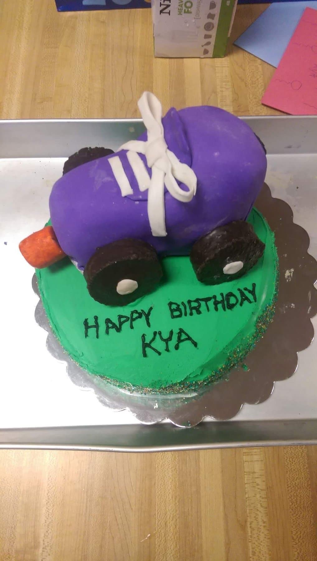 Roller skate birthday cake with green frosting and a purple skate topper by Jamie Cakes.