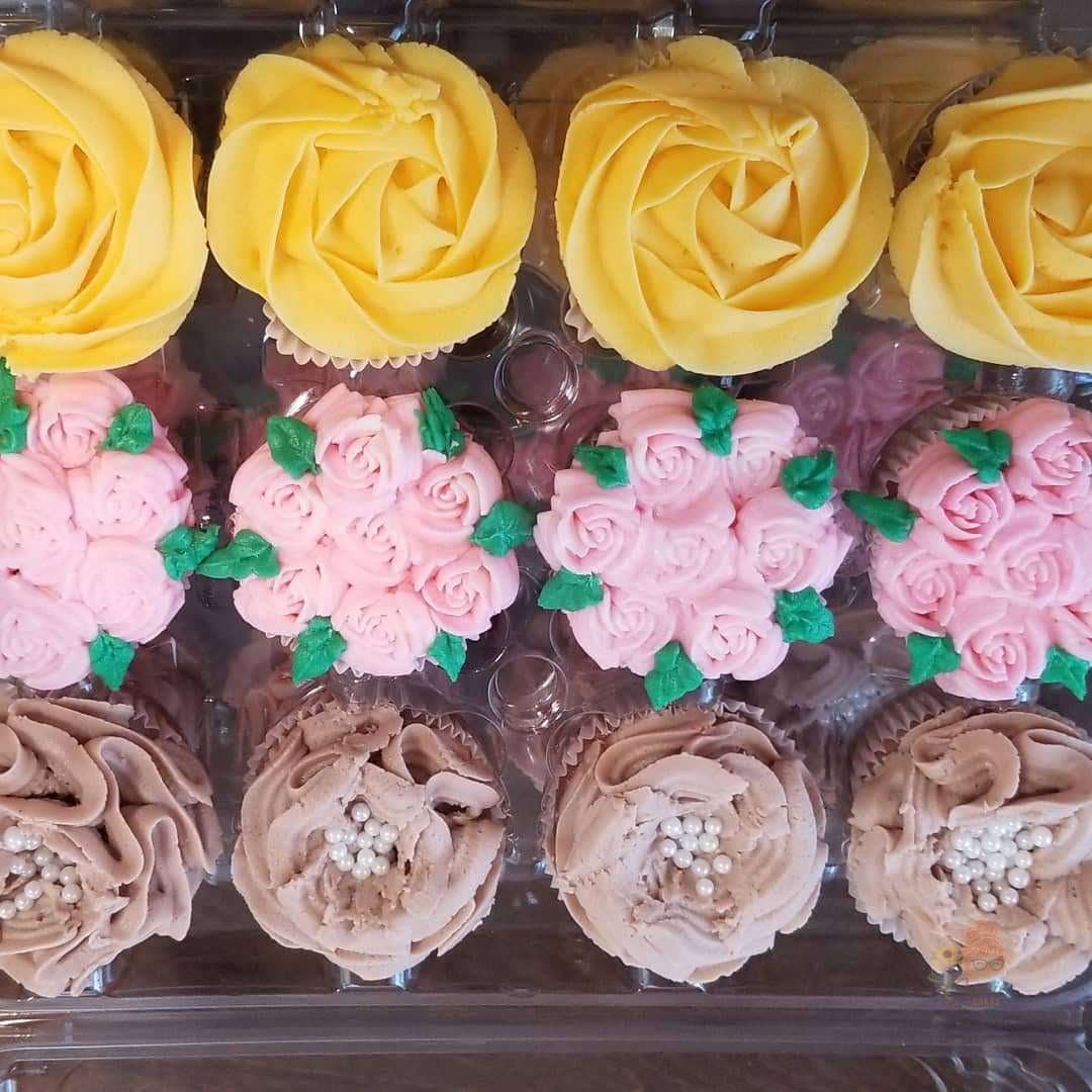 Floral buttercream cupcakes with yellow rosettes and pink blossoms by Jamie Cakes.